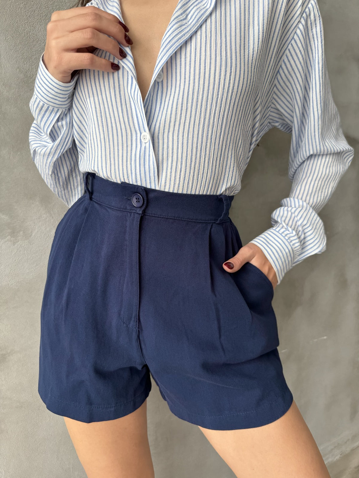 "Pantalones cortos de vestir en color azul marino, confeccionados en 100% algodón, con cintura elástica trasera para mayor comodidad y estilo versát
