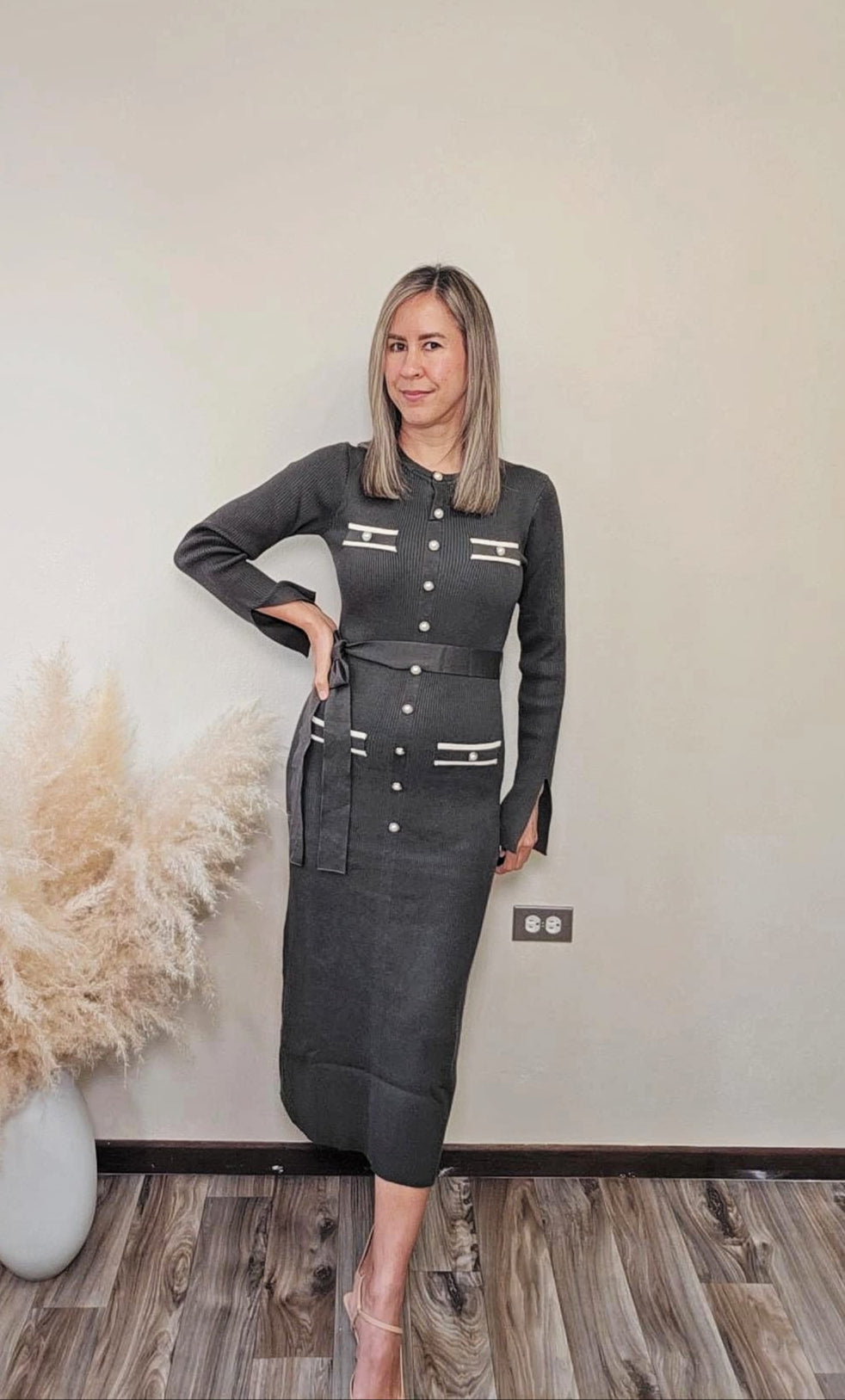 Foto de mujer de tez clara, cabello rubio está vistiendo un vestido de la colección de los new arrivals de Enso Amara Boutique.  Este vestido es midi, con botones frontales en el frente y diseño de botones.  Este vestido es color slay grey. Un hermoso vestido que puedes utilizar para una cita, una cena, una reunión, un día de mucho trabajo pero quieras estar cómoda o un día que simplemente quieras estar hermosa.  Compralo en la web.