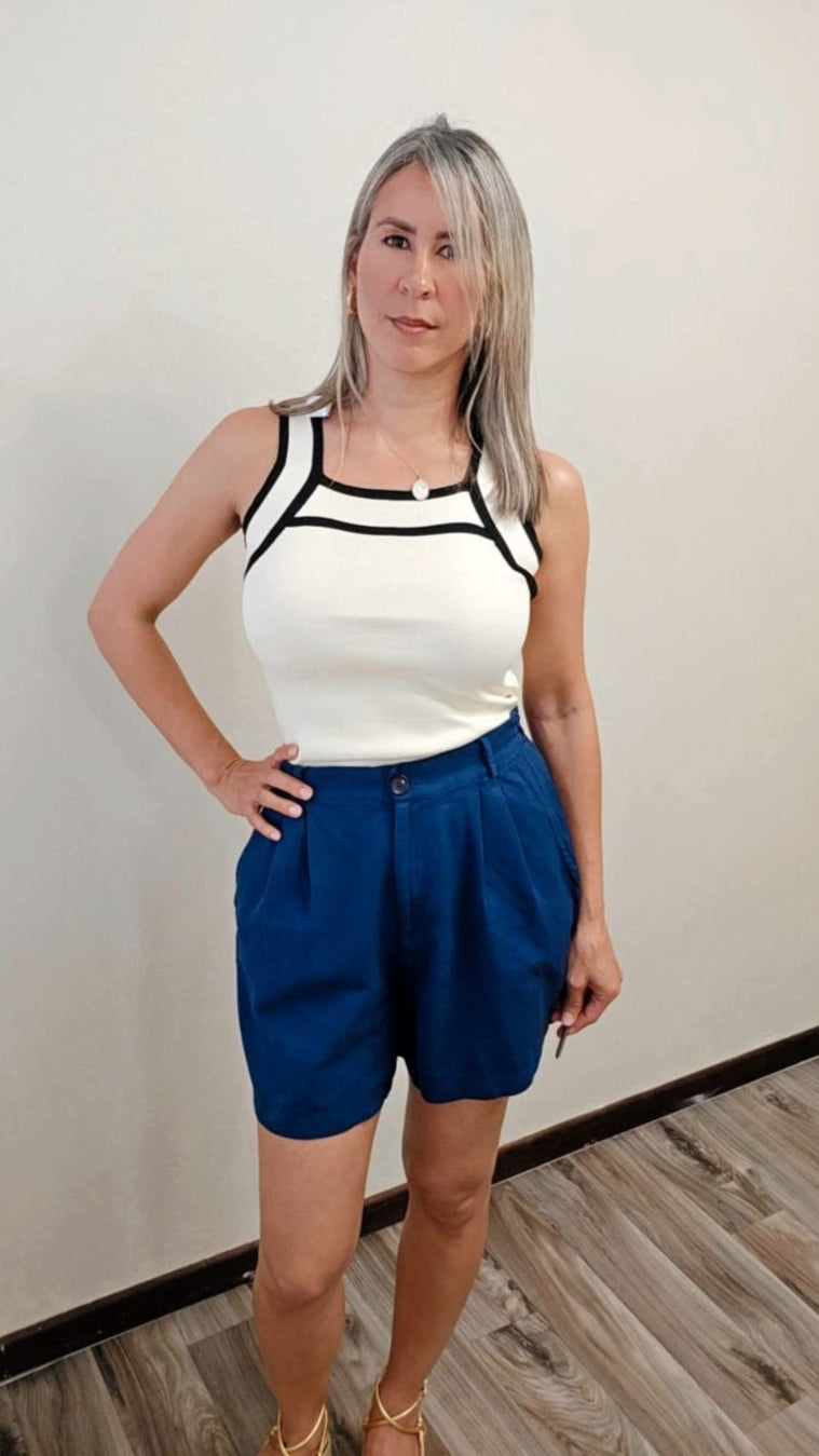 Camisa básica sin mangas, en tono vainilla con detalles negros en el escote y hombros, confeccionada en 100% acrílico; una pieza versátil para cualquier look I Enso Amara