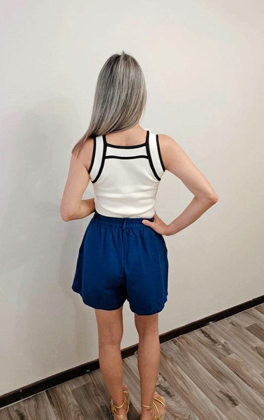 Prenda atemporal: camisa sin mangas de tono vainilla con detalles negros en los bordes, ideal para combinar con jeans, falda o atuendos elegantes. I Enso Amara