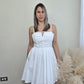 Foto de mujer modelando un vestido corto blanco.