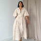 Vestido crema con diseño de ojales, botones frontales y cinturón incluido; confeccionado en 100% algodón y forrado para un estilo fresco y elegante