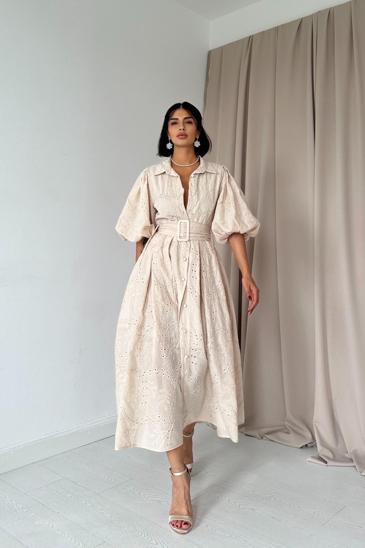 Vestido crema con diseño de ojales, botones frontales y cinturón incluido; confeccionado en 100% algodón y forrado para un estilo fresco y elegante